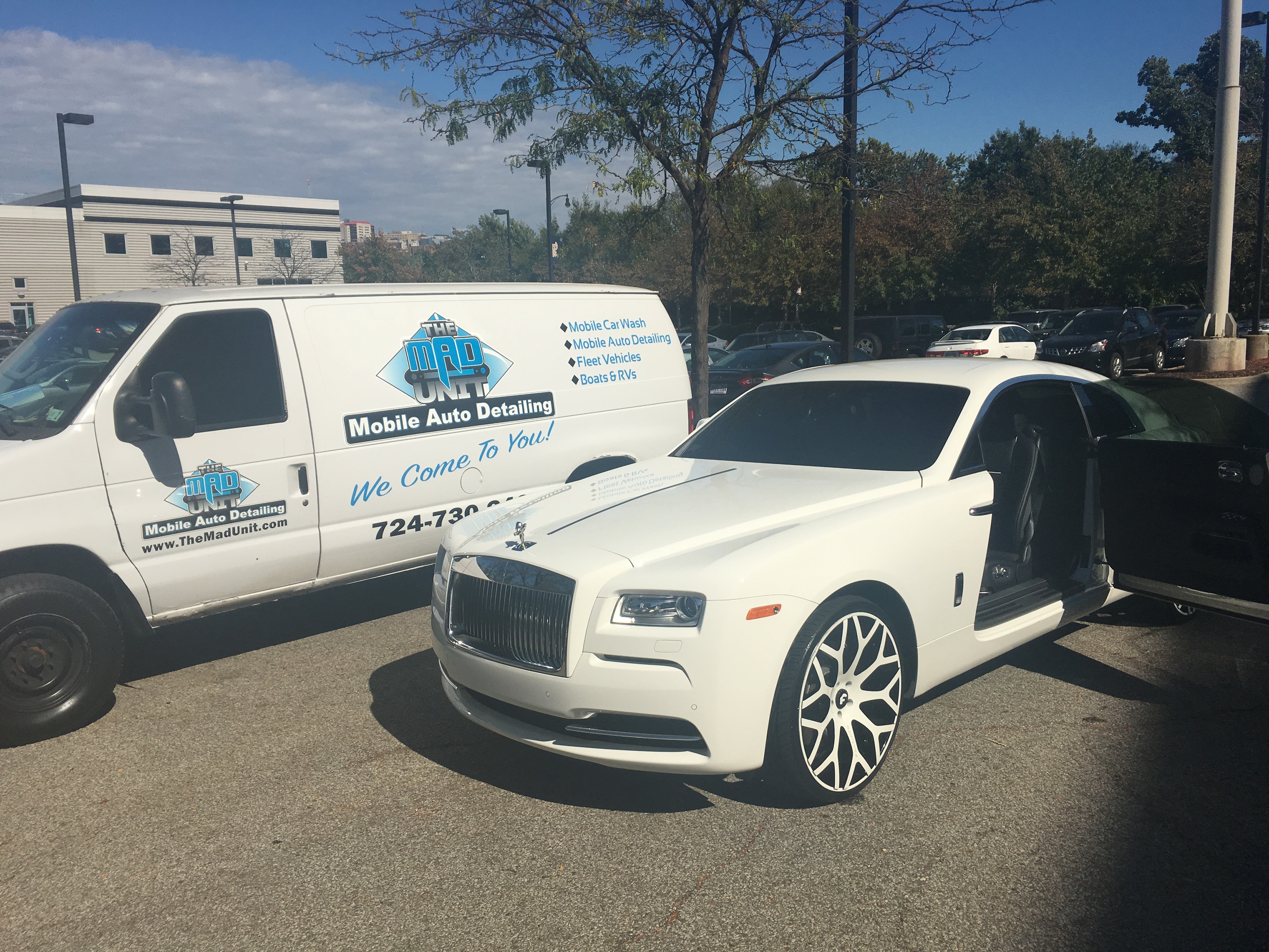 White Rolls-Royce doors open with MAD Unit van